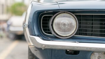 Close up of vintage old car with faded color and rust on the side