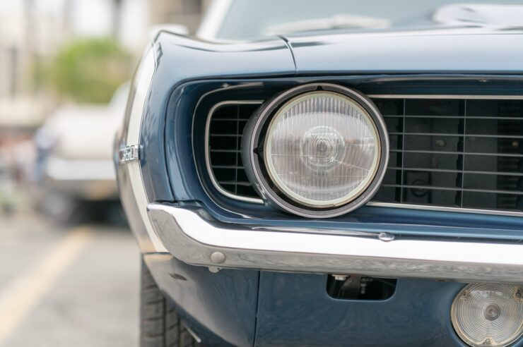 Close up of vintage old car with faded color and rust on the side