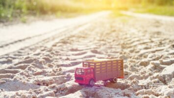 Toy retro truck on the road - symbol of cargo transportation