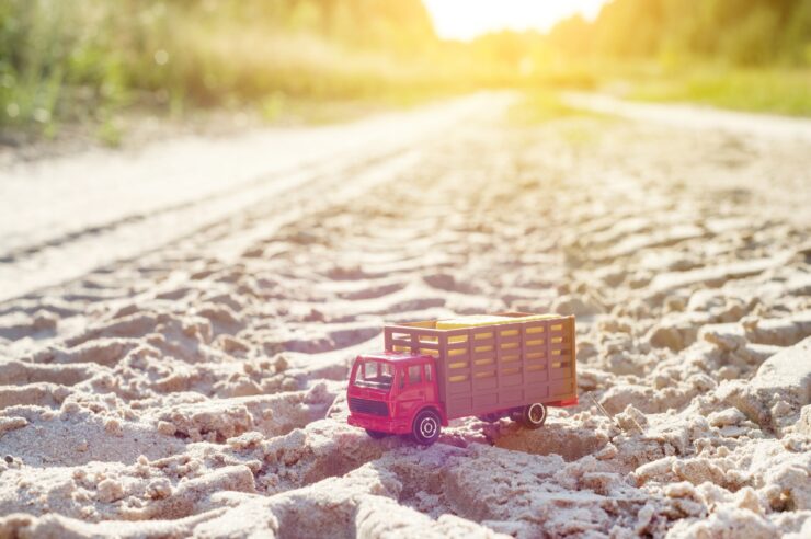 Toy retro truck on the road - symbol of cargo transportation